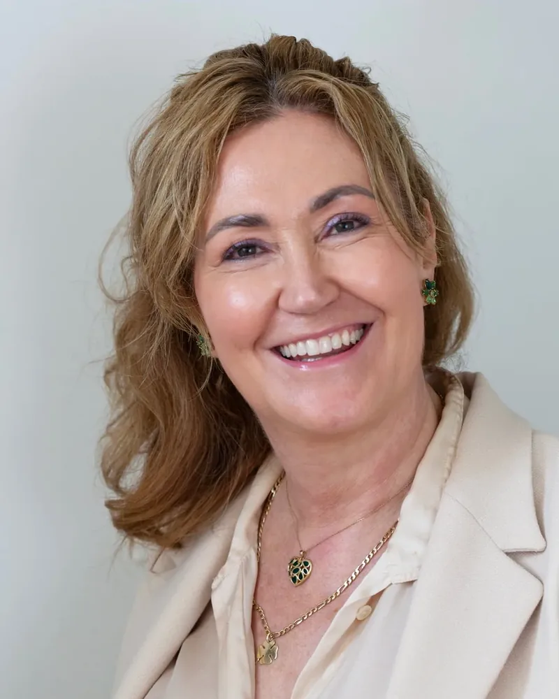 Portret van Ilse Bink, lachend, in een lichte blazer.
